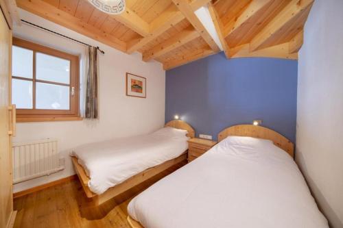 deux lits dans une petite pièce avec une fenêtre dans l'établissement Schöneben Chalet Schiffer, à Wald im Pinzgau