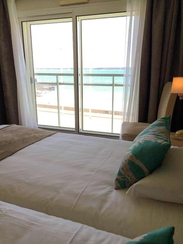 a bedroom with a bed with a view of the ocean at Brit Hôtel De L'océan in Concarneau