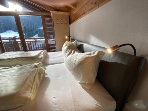 a bedroom with a bed with pillows and a lamp at Schöneben Haus Arnika in Wald im Pinzgau