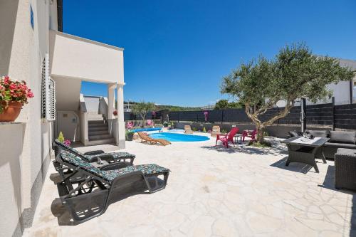a patio with two chairs and a swimming pool at Apartments Feliks in Ljubač