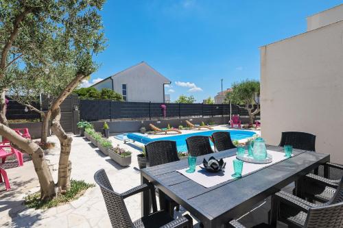a patio with a table and chairs and a pool at Apartments Feliks in Ljubač