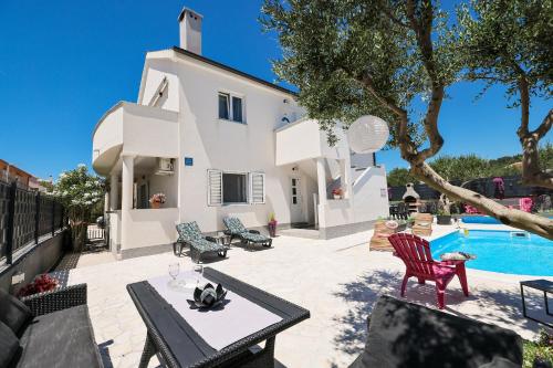 a villa with a swimming pool and a house at Apartments Feliks in Ljubač