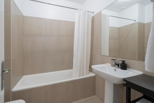 a bathroom with a sink and a bath tub and a mirror at Apartamento Princesa Dona Amélia by An Island Apart in Funchal