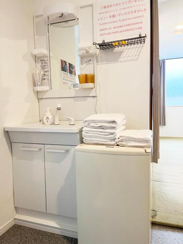 a white bathroom with a sink and a mirror at Hananosato Hotel 池袋本店 in Tokyo