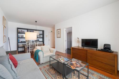 a living room with a couch and a tv at Apartamento Princesa Dona Amélia by An Island Apart in Funchal