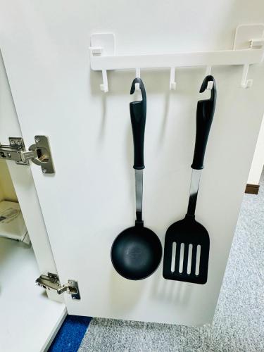 two black spatulas hanging on a wall at Kamizawa Villa - BBQ x オーシャンビュー in Kumiage