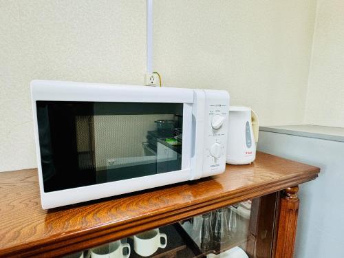 a microwave sitting on top of a wooden table at Kamizawa Villa - BBQ x オーシャンビュー in Kumiage
