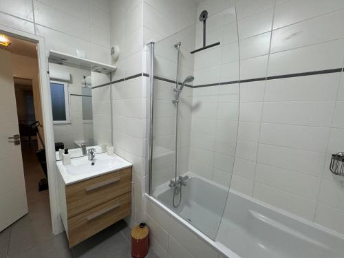 une salle de bain blanche avec une douche et un lavabo dans l'établissement ROMARIN-Gares, à Lille