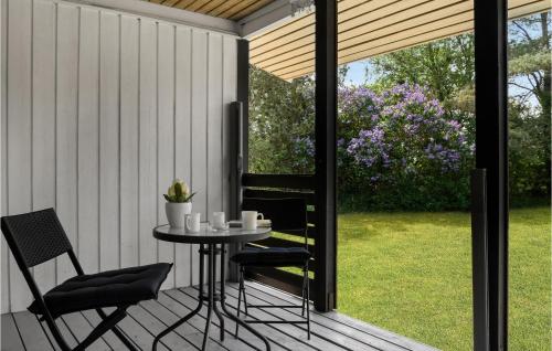 a patio with a table and chairs on a deck at Holiday Home Mælkebøttevej Nakskov in Kappel