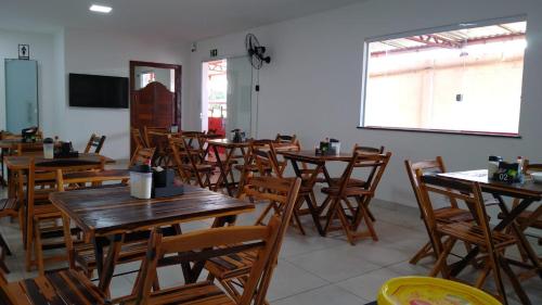 a room with wooden tables and chairs in a restaurant at Pousada e Restaurante Br101 in Santo Antônio de Jesus