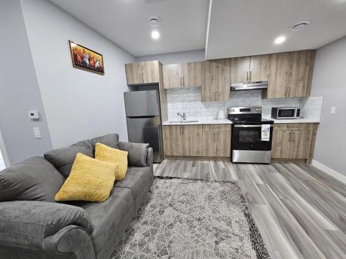 Una sala de estar con un sofá y una cocina. en Cozy 2bed Guest suite, en Calgary