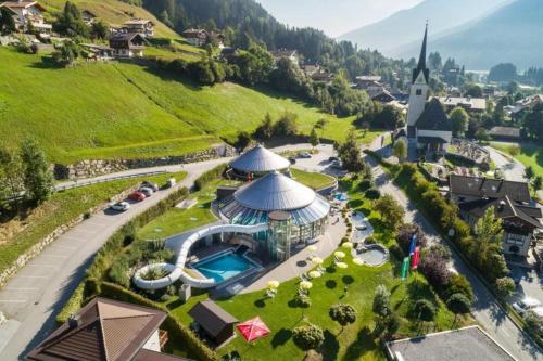 an aerial view of a resort with a pool and a church at Schöneben Haus Wikinge in Wald im Pinzgau