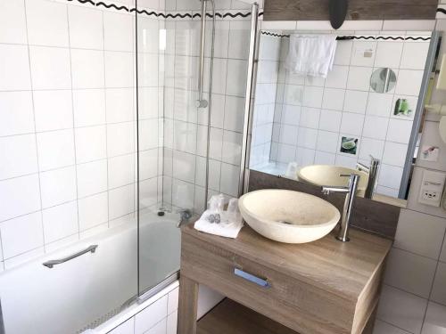 a bathroom with a sink and a shower at Brit Hotel Aux Sacres Reims, Centre Historique in Reims