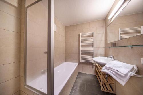 une salle de bain avec une douche, une baignoire et un lavabo dans l'établissement Schöneben Chalet Anton, à Wald im Pinzgau
