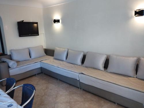 Un sofá largo con almohadas sentado en una habitación. en Cosy appartement Front de mer - Marina Studio, en Marina Smir