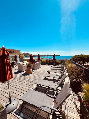 - une rangée de chaises longues sur une terrasse avec la plage dans l'établissement Magnifique Appartement Climatisé Vue Mer Ref LA PLAGE, à Agay