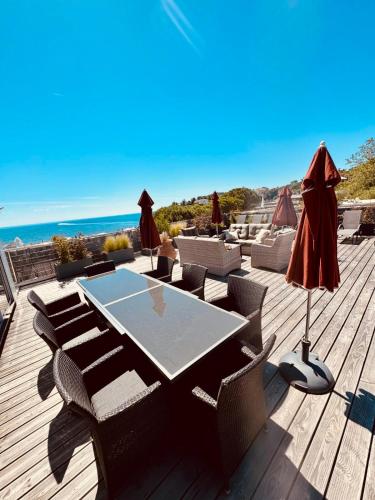 un patio avec une table et des chaises et l'océan dans l'établissement Magnifique Appartement Climatisé Vue Mer Ref LA PLAGE, à Agay