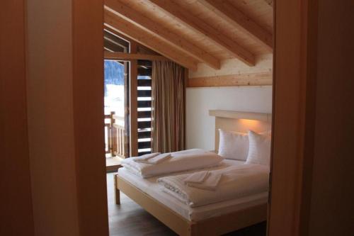 une chambre avec un lit dans une pièce avec une fenêtre dans l'établissement Schöneben Haus Silberdistel, à Wald im Pinzgau