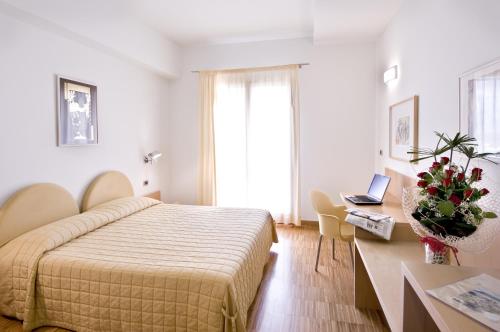 a bedroom with a bed and a desk with a laptop at Grand Hotel Garden in Barile