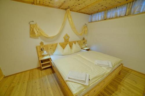 a bedroom with a large bed with a wooden floor at Schöneben Haus Elisabeth in Wald im Pinzgau