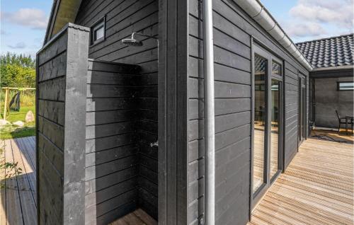 a black house with a wooden deck at Gorgeous Home In Sjølund With Kitchen in Sjølund