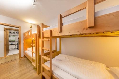 ein Zimmer mit drei Etagenbetten und einem Flur in der Unterkunft Schöneben Chalet Edelhirsch in Wald im Pinzgau