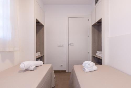 two beds in a room with white walls and mirrors at Rentalmar Murillo Plus in Salou