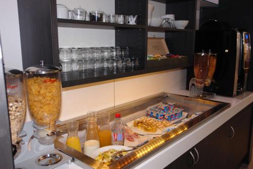 a kitchen counter with a buffet of food and drinks at Brit Hotel Confort Rouen Centre in Rouen