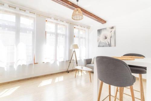 un salon blanc avec une table et des chaises dans l'établissement Appartement spacieux et fonctionnel - centre, à Douai