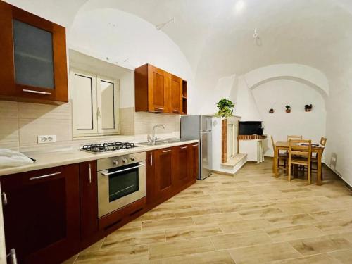 a kitchen with wooden cabinets and a stove top oven at A casa di nonna in Fondi
