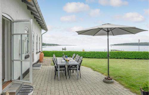 a table and chairs with an umbrella on a patio at Holiday Home Sønderballevej Rødekro in Rødekro
