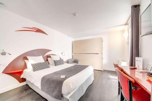 a hotel room with a bed and a desk at Brit Hotel Porte d'Espagne in Perpignan