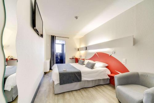 a hotel room with a bed and a chair at Brit Hotel Porte d'Espagne in Perpignan