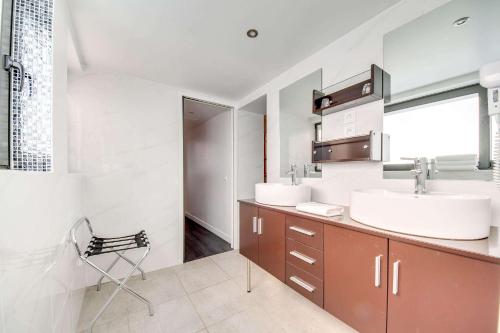 a bathroom with two sinks and a chair in it at Brit Hotel Porte d'Espagne in Perpignan