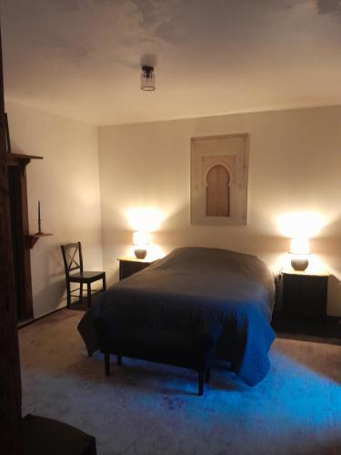 una camera da letto con un letto e due luci su due tavoli di La petite Salamandre bleue a La Croisille-sur-Briance