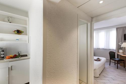 日內瓦的住宿－日內瓦中心一室公寓，一间带镜子的浴室和一间带桌子的房间
