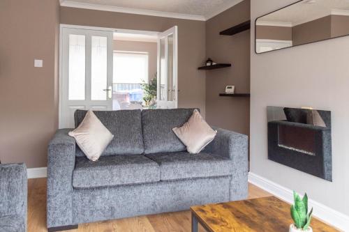 a living room with a couch and a table at Beauly House in Falkirk