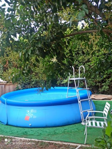 une piscine bleue avec une échelle et une chaise à côté dans l'établissement maison 3 chambres piscine près Avignon 4 jours minimum, au Pontet