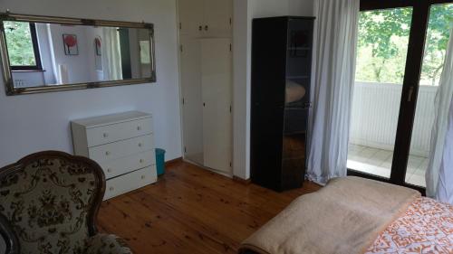 a bedroom with a chair and a dresser and a mirror at Pensjonat Kowalski in Łubowo