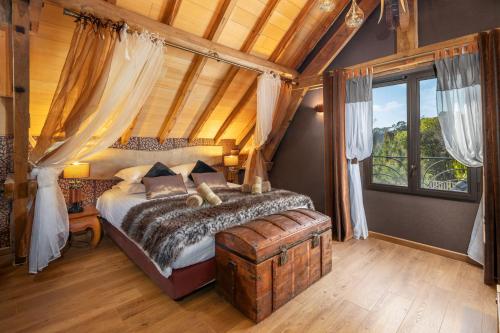 une chambre avec un lit à baldaquin dans l'établissement Domaine de Campagnac - Spa & Sauna, à Carsac-Aillac