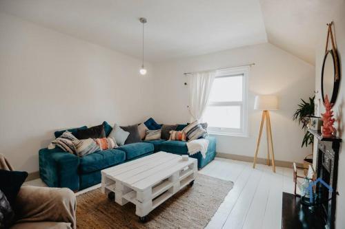 a living room with a blue couch and a coffee table at Indigo Snug - Gorgeous 2 bed flat in the heart of Cromer in Cromer