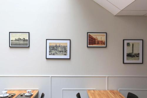 a dining room with pictures on the wall at Brit Hotel Calais in Calais