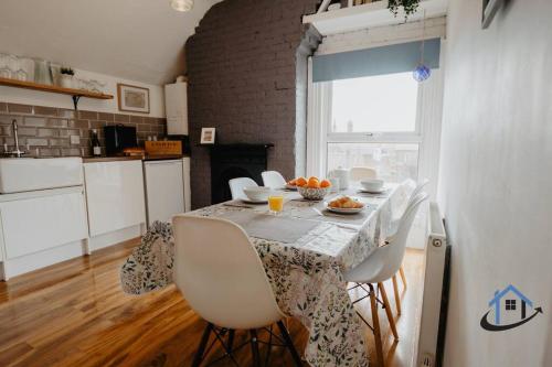 a kitchen with a table with chairs and a window at Indigo Snug - Gorgeous 2 bed flat in the heart of Cromer in Cromer