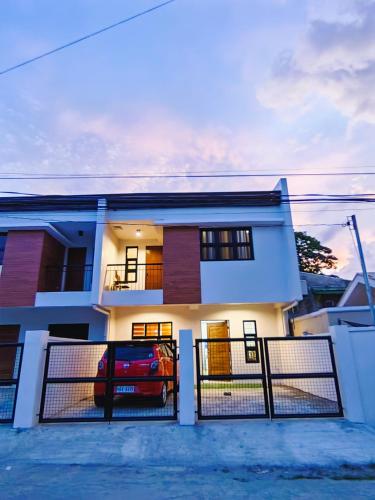 a house with a car parked in front of it at Host Homes Apartelle in San Jose in Tacloban