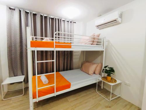 a bedroom with two bunk beds in a room at Host Homes Apartelle in San Jose in Tacloban