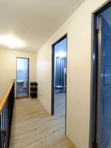 a hallway with a door leading to a room at Host Homes Apartelle in San Jose in Tacloban
