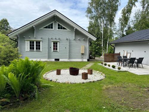 a house with a yard with a fire pit at Upea villa lähellä rantaa poreallas & SUP-laudat in Vaasa