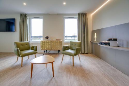 un salon avec deux chaises et une table dans l'établissement Brit Hotel Confort Saint-Dizier, à Saint-Dizier