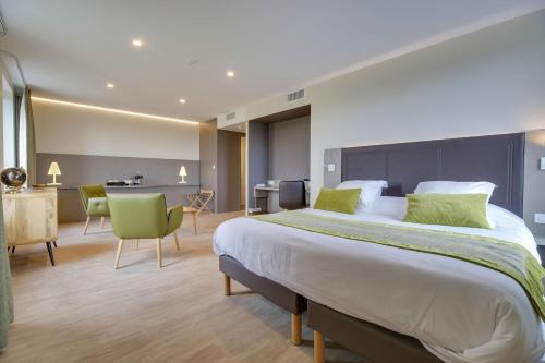 a hotel room with a large bed and a desk at Brit Hotel Confort Saint-Dizier in Saint-Dizier