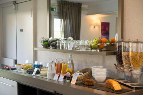 a kitchen counter with a bunch of food on it at Brit Hotel Essentiel de Granville in Granville